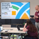 Winchester Public Schools' Superintendent Jason Van Heukelum talking next to the Strategic Planning session slide presentation