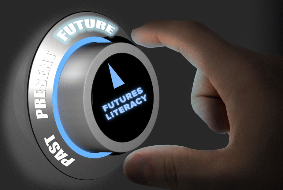 Hand turning a dial labeled Futures Literacy. The dial points to the word "Future."