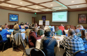 REMC educators sitting at tables in a professional learning session.