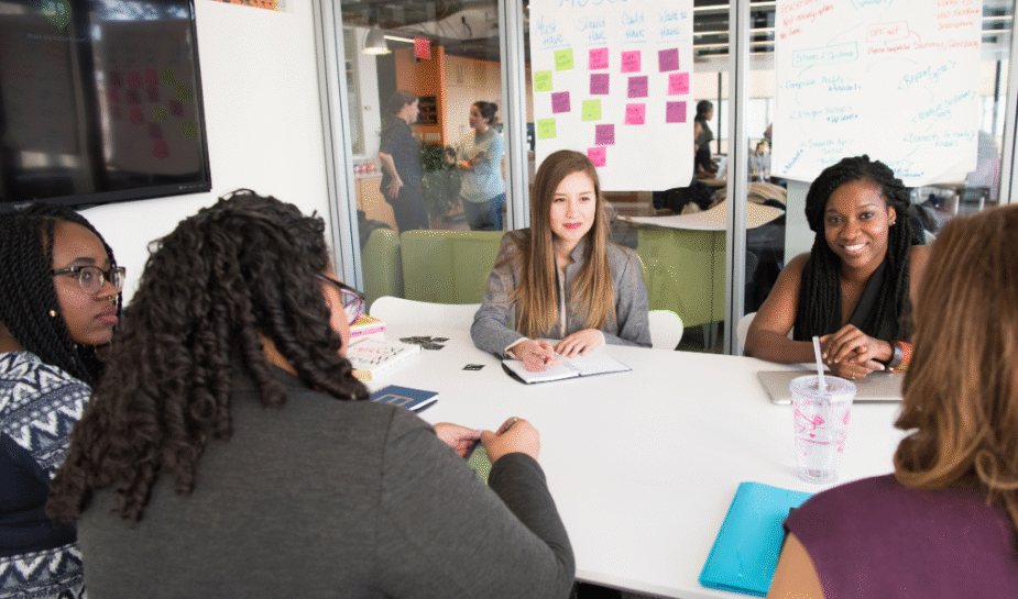 Professional people sitting at a conference table and taking notes.